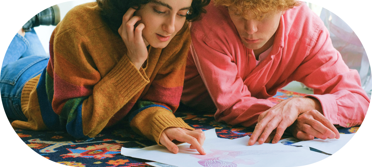 Dos personas jóvenes mirando unos bocetos