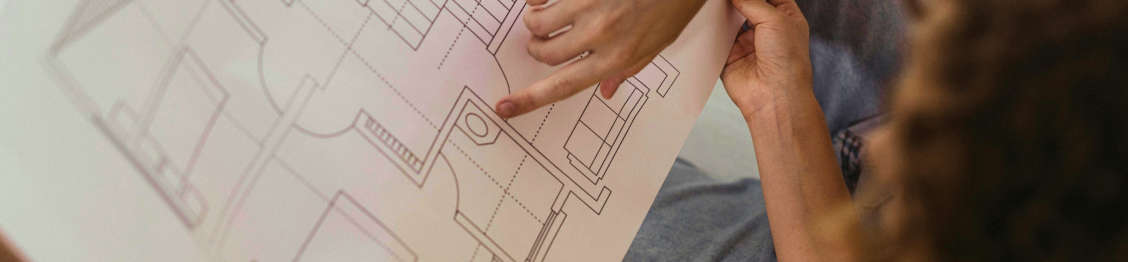 Dos personas mirando el plano de una edificación